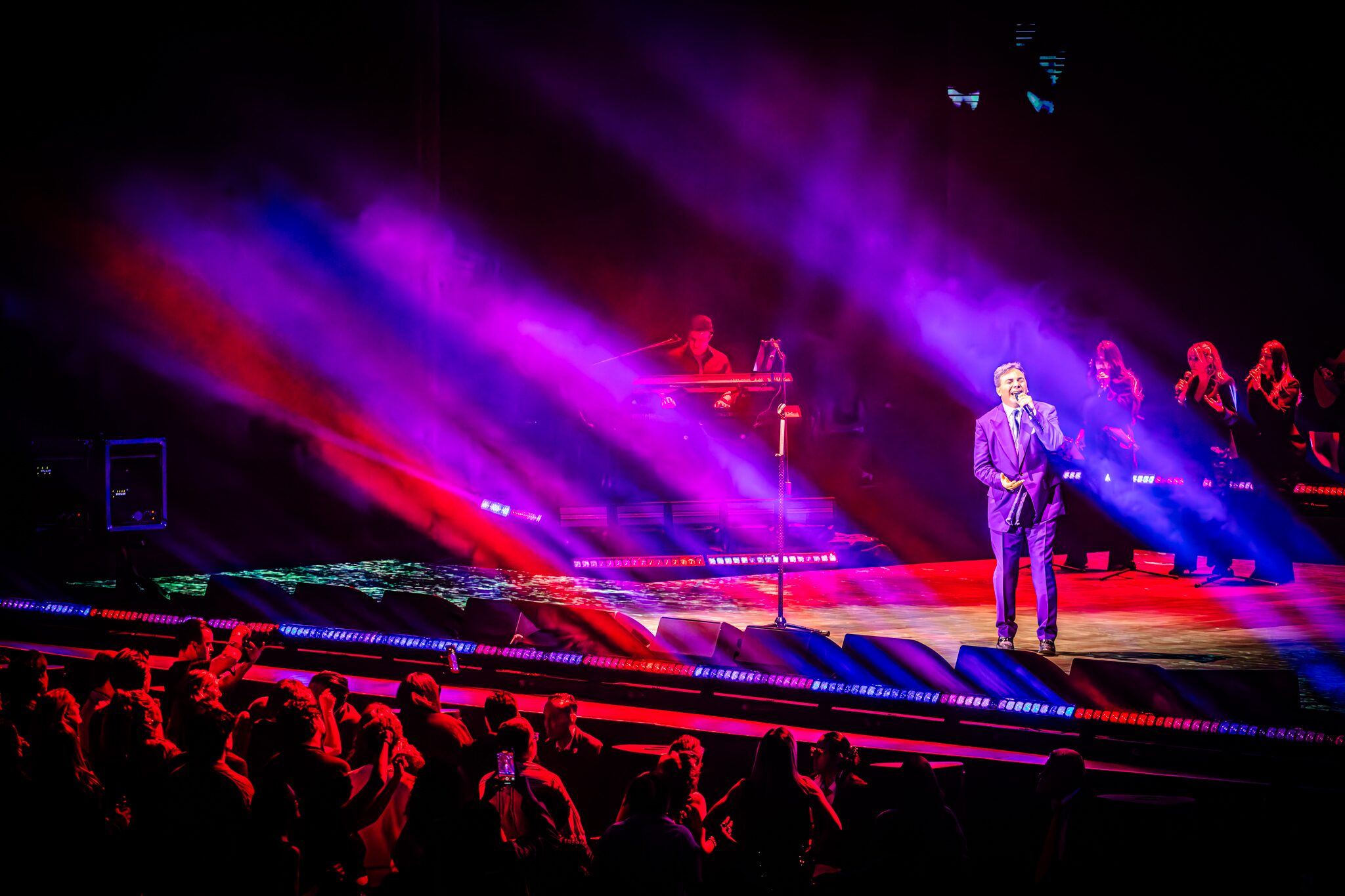 Cristian Castro en escenario con luces magenta